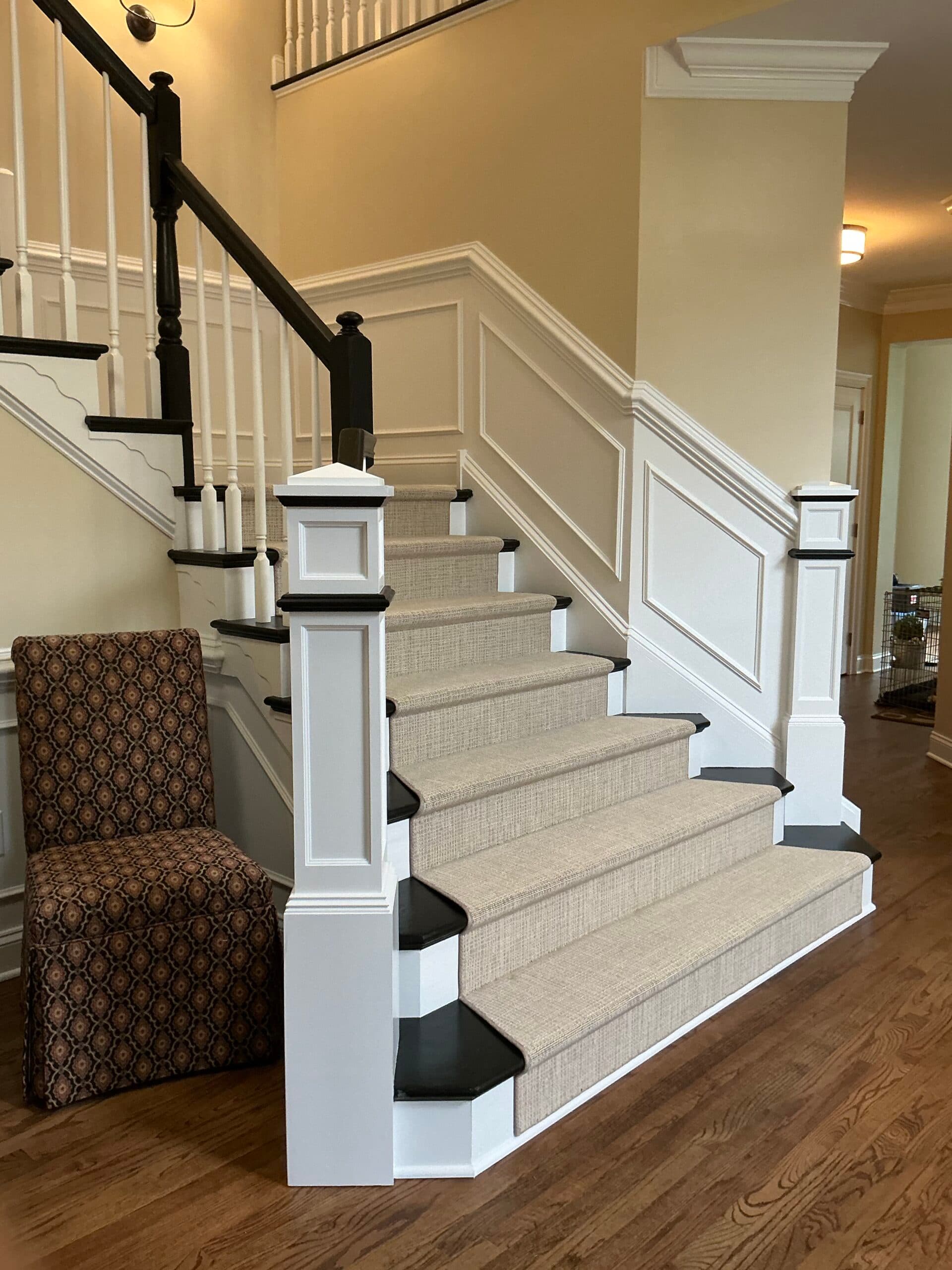Renovated staircase with custom wainscoting and refinished hardwoods by Harlan Custom Contracting